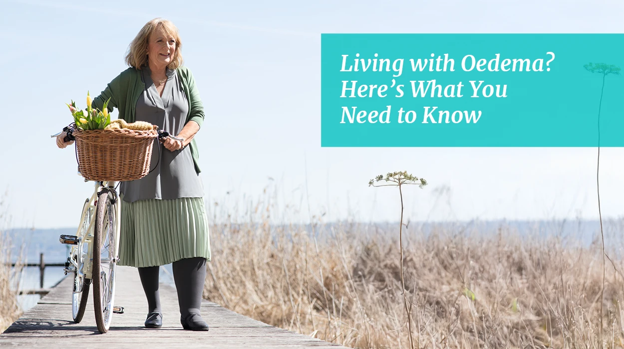 A lady with lyphedema stands next to her bike in nature