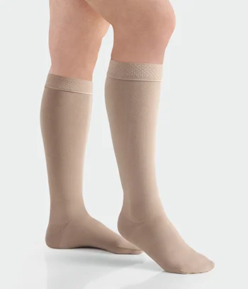 A pair of Juzo move medical compression stockings beige color