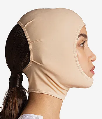 Side view of a female model wearing a facial face-lift compression face mask.